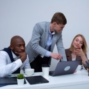 3 persons from a startup gathered together in front of a pc