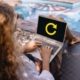 Woman refocusing on her business while working on a laptop by the pool